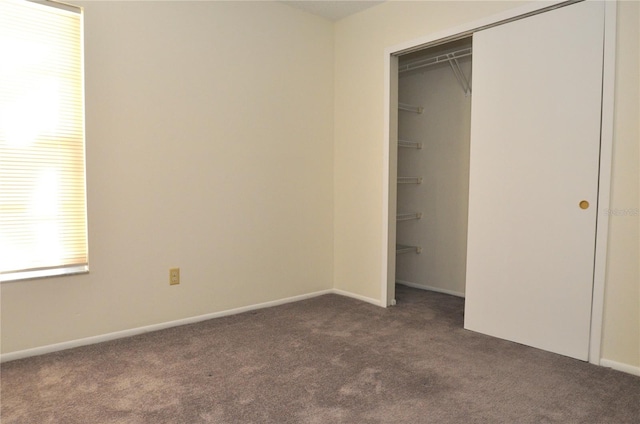 unfurnished bedroom featuring a closet, carpet flooring, and baseboards