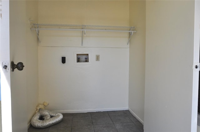 laundry area featuring hookup for a washing machine, hookup for an electric dryer, laundry area, dark tile patterned floors, and baseboards