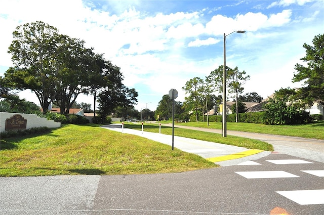 view of street with sidewalks, traffic signs, and street lights