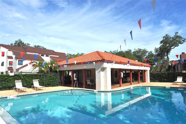 community pool featuring a patio area and fence