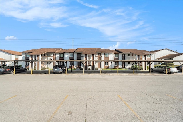 view of building exterior featuring covered parking and a residential view