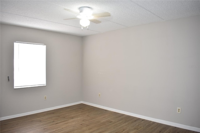 empty room featuring a textured ceiling, baseboards, and wood finished floors