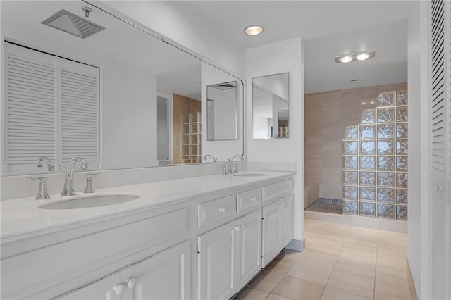 bathroom featuring double vanity, tile patterned floors, walk in shower, and a sink