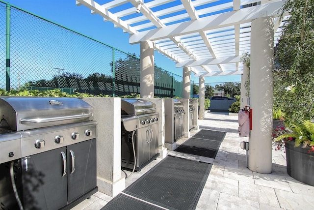 view of patio with an outdoor kitchen, fence, a pergola, and grilling area