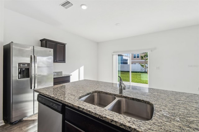 kitchen featuring wood finished floors, a sink, visible vents, appliances with stainless steel finishes, and light stone countertops