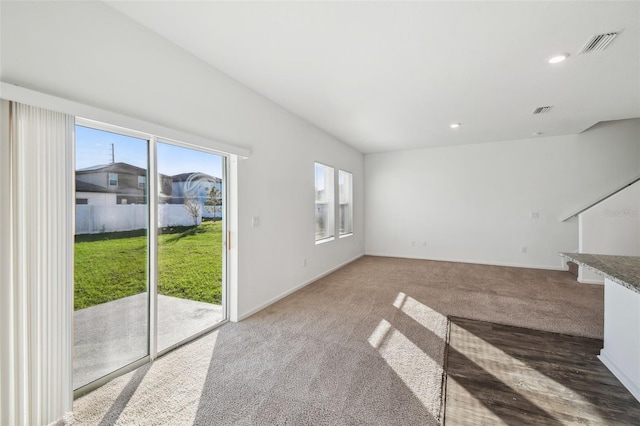 unfurnished living room featuring baseboards, carpet flooring, visible vents, and recessed lighting