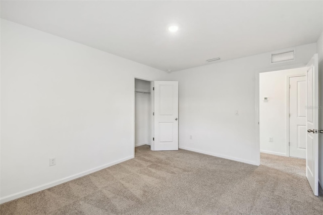 empty room featuring carpet flooring, visible vents, and baseboards