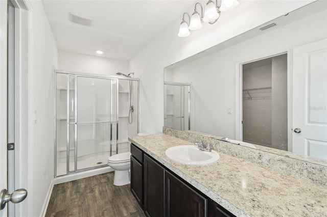 full bath with visible vents, toilet, wood finished floors, vanity, and a shower stall