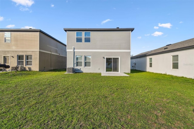 rear view of house with central air condition unit and a yard