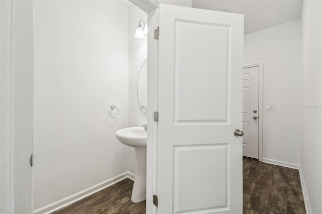 bathroom with a sink, wood finished floors, and baseboards