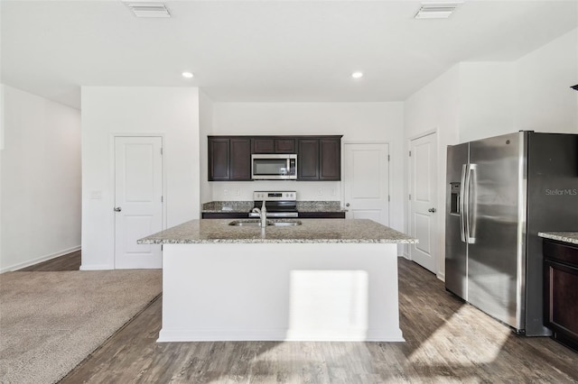 kitchen with appliances with stainless steel finishes, a center island with sink, a sink, and visible vents