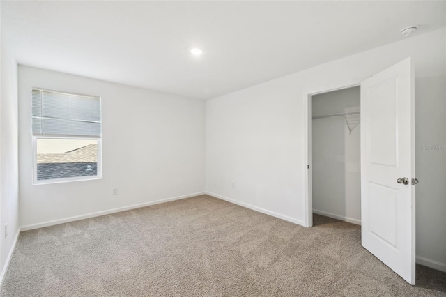 unfurnished bedroom featuring carpet, a closet, and baseboards