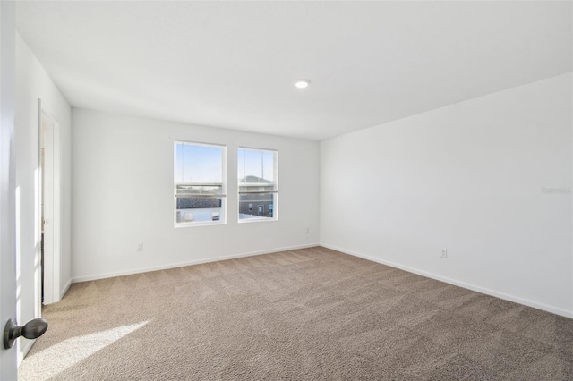 empty room with baseboards and carpet flooring