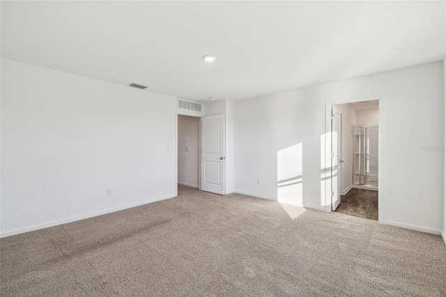 spare room featuring carpet, visible vents, and baseboards