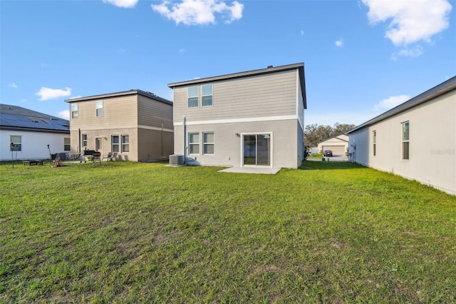 rear view of property featuring a lawn and central AC