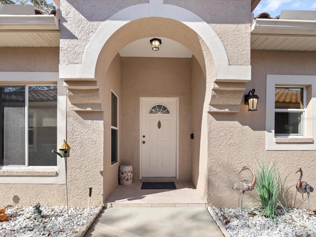 view of exterior entry featuring stucco siding