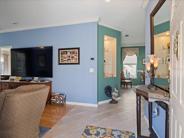 foyer with visible vents, light wood-style flooring, ornamental molding, a textured ceiling, and baseboards