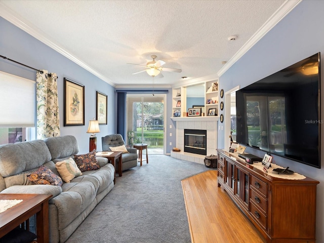 living area with a fireplace, crown molding, light carpet, ceiling fan, and a textured ceiling