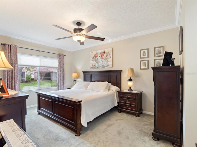 bedroom featuring light carpet, baseboards, a ceiling fan, ornamental molding, and a textured ceiling