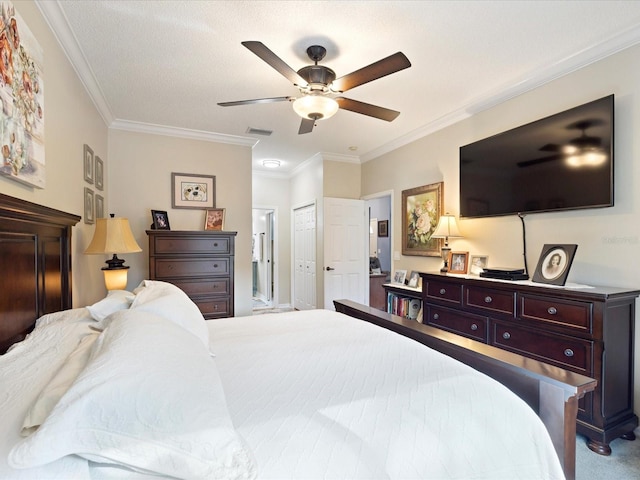 carpeted bedroom with ornamental molding, a closet, visible vents, and a ceiling fan