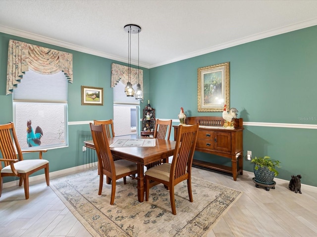 dining room featuring baseboards, crown molding, and wood finished floors