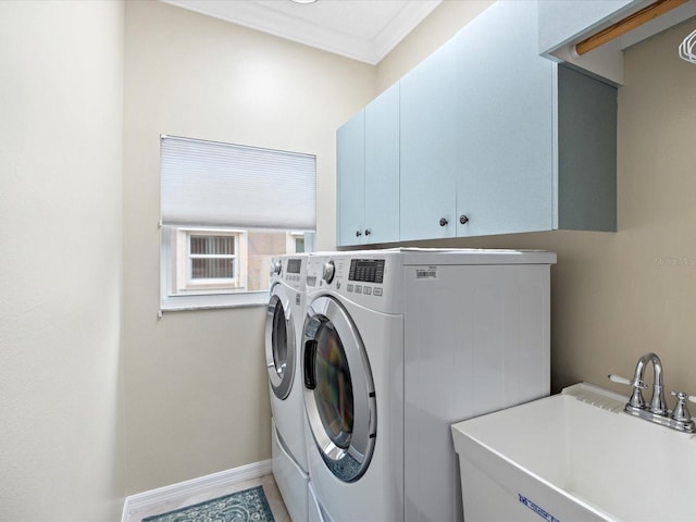 laundry area with cabinet space, baseboards, washer and clothes dryer, crown molding, and a sink