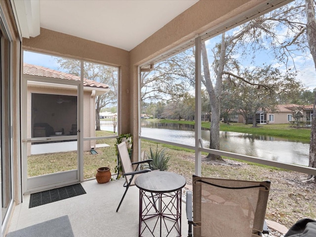 sunroom / solarium featuring a water view