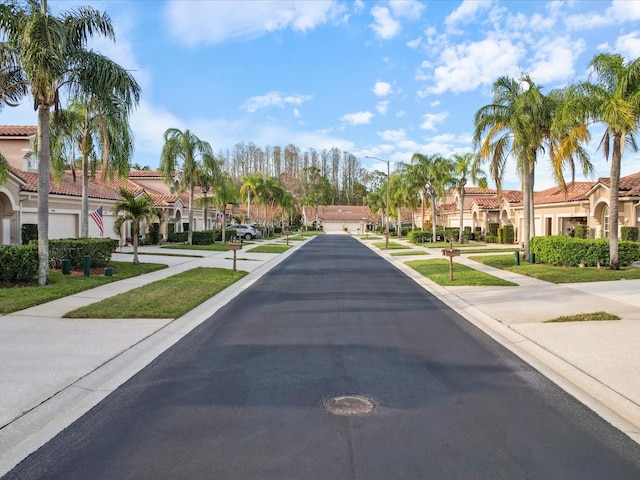 view of road featuring street lighting, sidewalks, and a residential view