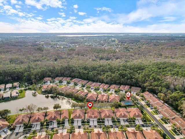 drone / aerial view featuring a water view, a residential view, and a view of trees