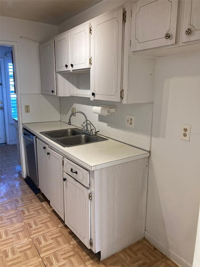 kitchen featuring a sink, white cabinetry, light countertops, and dishwasher