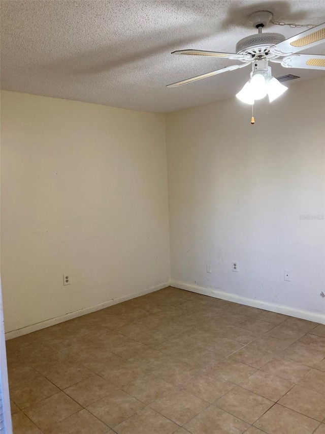 empty room featuring a ceiling fan, a textured ceiling, and baseboards