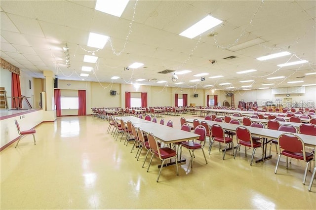 dining space with a drop ceiling, visible vents, and tile patterned floors