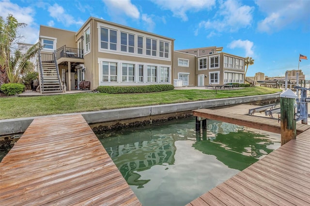 dock area featuring boat lift, stairway, and a yard