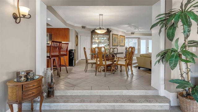 dining space featuring visible vents, ornamental molding, track lighting, and light tile patterned flooring