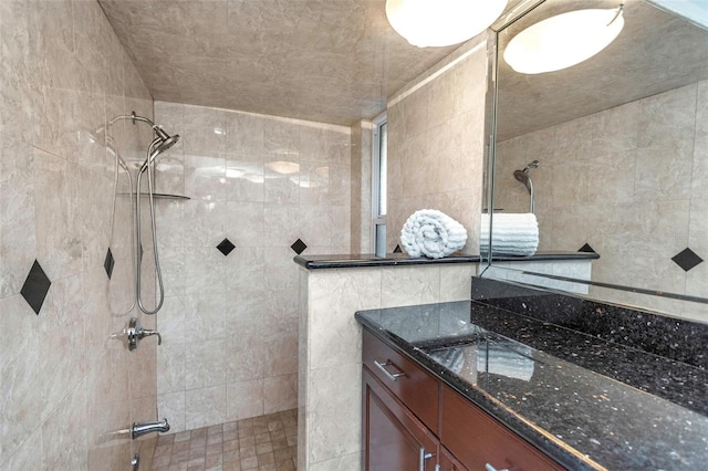 bathroom featuring a walk in shower, tile walls, and vanity