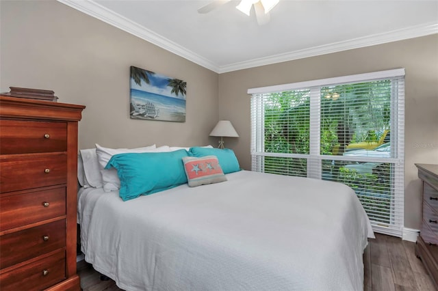 bedroom featuring ornamental molding, dark wood-type flooring, and a ceiling fan