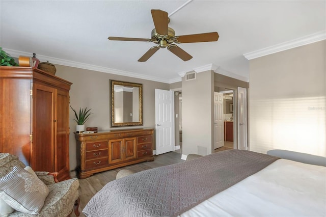 bedroom featuring ornamental molding, visible vents, ceiling fan, and wood finished floors