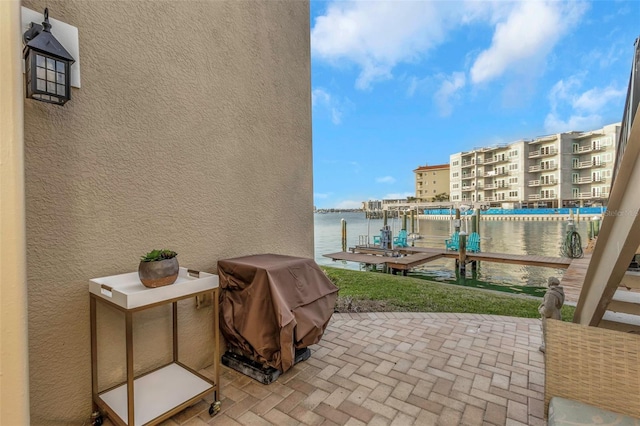 view of patio / terrace featuring a dock, a water view, boat lift, and grilling area