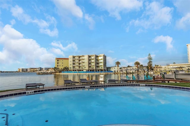 view of pool featuring a water view and a dock