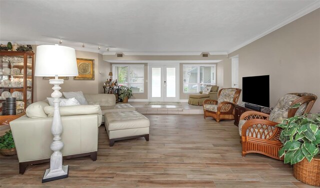 living area featuring crown molding, baseboards, french doors, light wood-type flooring, and track lighting