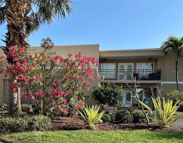 view of front of home with a balcony and stucco siding