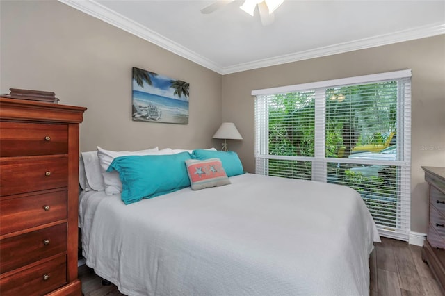 bedroom featuring dark wood finished floors, baseboards, ornamental molding, and ceiling fan