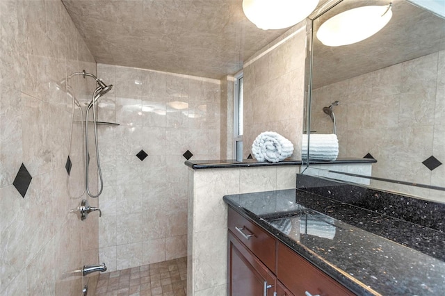 full bathroom featuring walk in shower, tile walls, and vanity