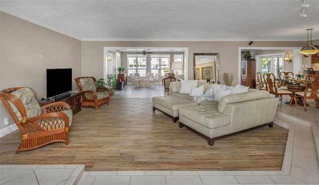 living room with ceiling fan, baseboards, crown molding, and light wood finished floors