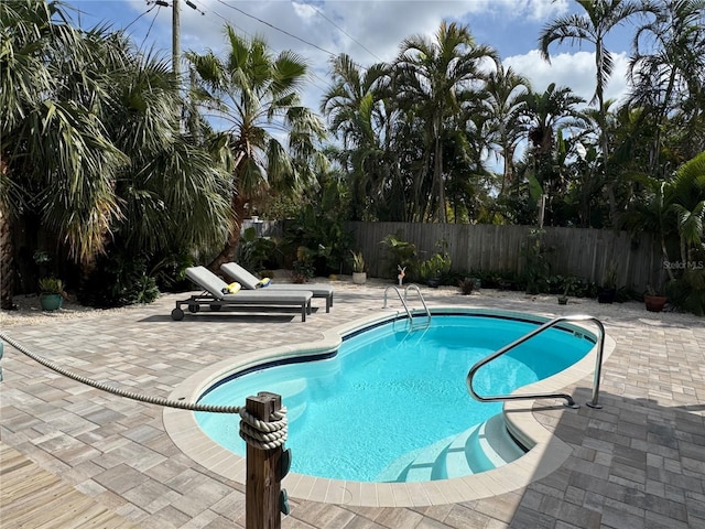 view of pool with a fenced in pool, a patio area, and fence