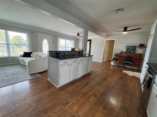 kitchen with visible vents, a ceiling fan, dark countertops, open floor plan, and dark wood-type flooring