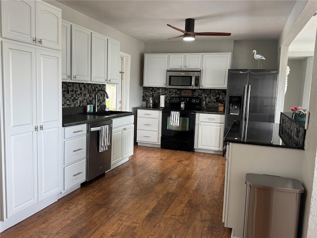 kitchen featuring a sink, white cabinetry, appliances with stainless steel finishes, dark wood-style floors, and dark countertops