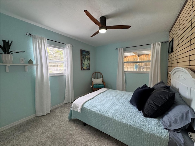 bedroom with a textured ceiling, carpet, a ceiling fan, and baseboards