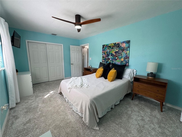 carpeted bedroom featuring baseboards, ceiling fan, visible vents, and a closet