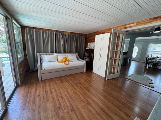 unfurnished bedroom featuring wooden ceiling, wood walls, and wood finished floors